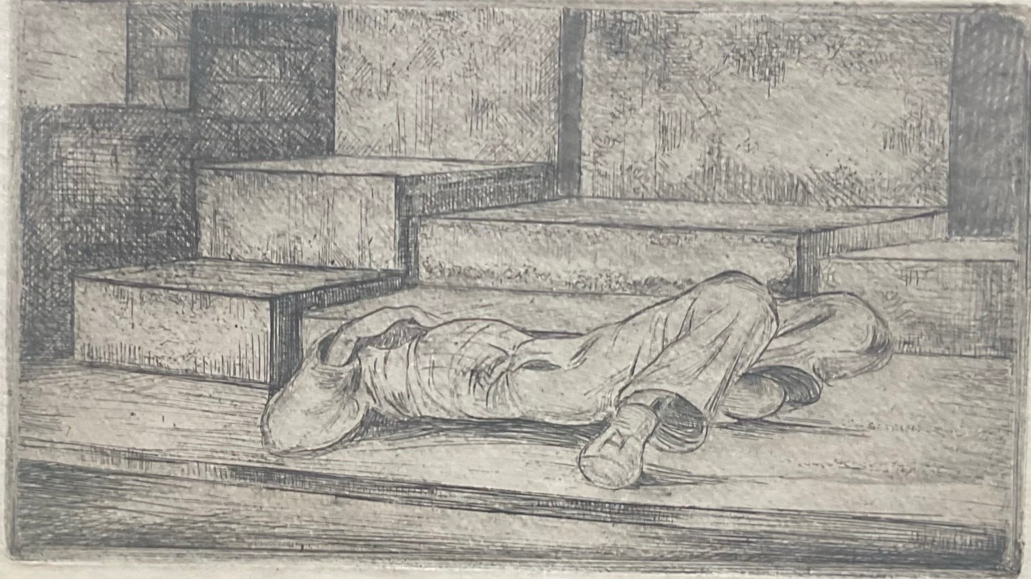 Street scene depicting a person lying beside a wall