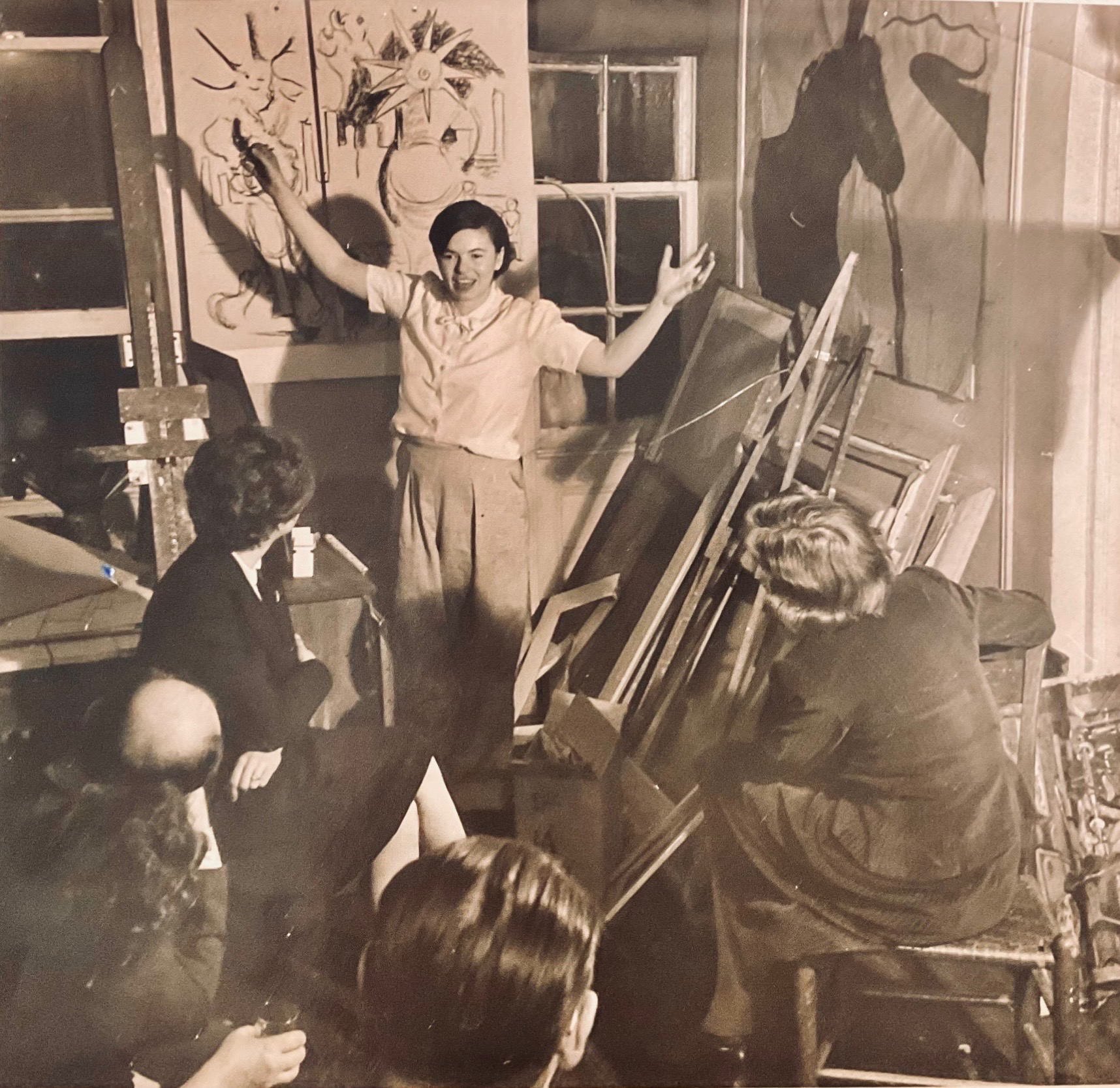 Edith Kramer demonstrating a pose to a group in a studio